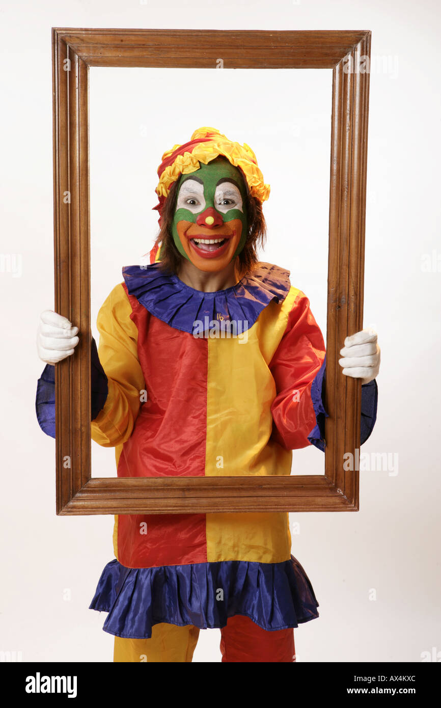 Ritratto di un joker tenendo una cornice immagine e sorridente Foto Stock