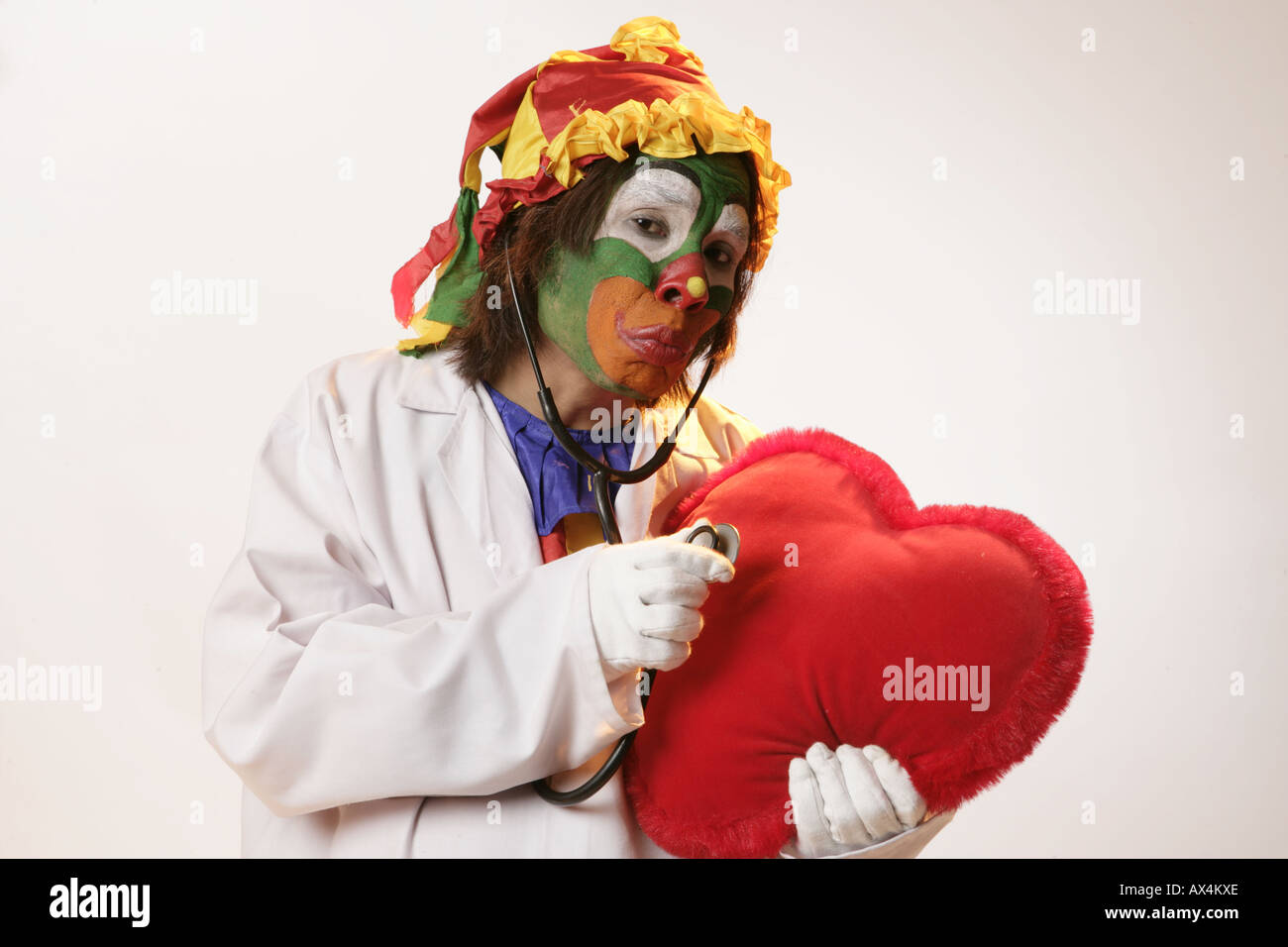 Ritratto di un joker esaminando un cuore con uno stetoscopio Foto Stock