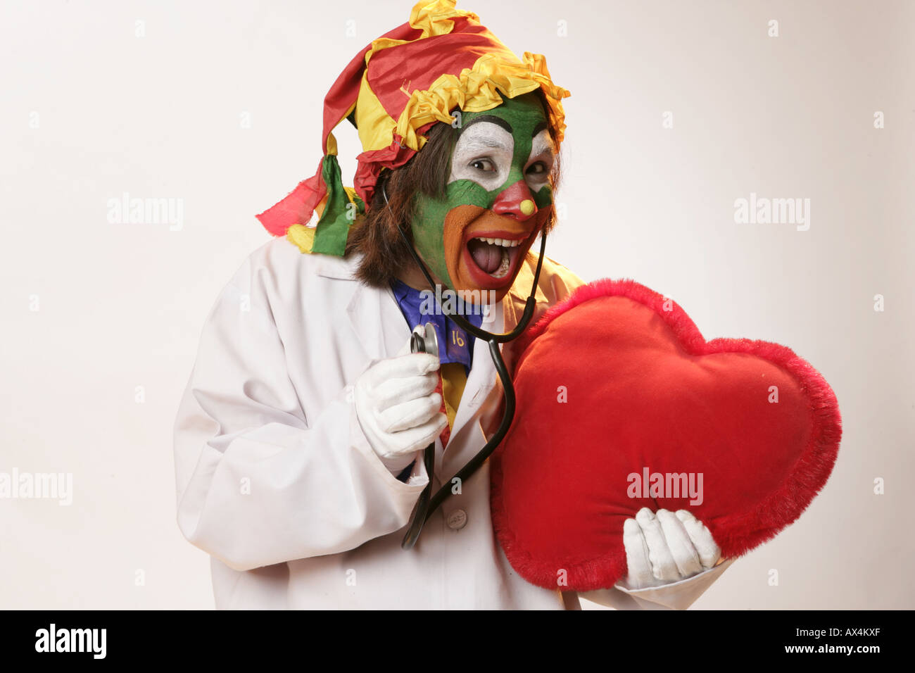 Ritratto di un joker esaminando un cuore con uno stetoscopio Foto Stock