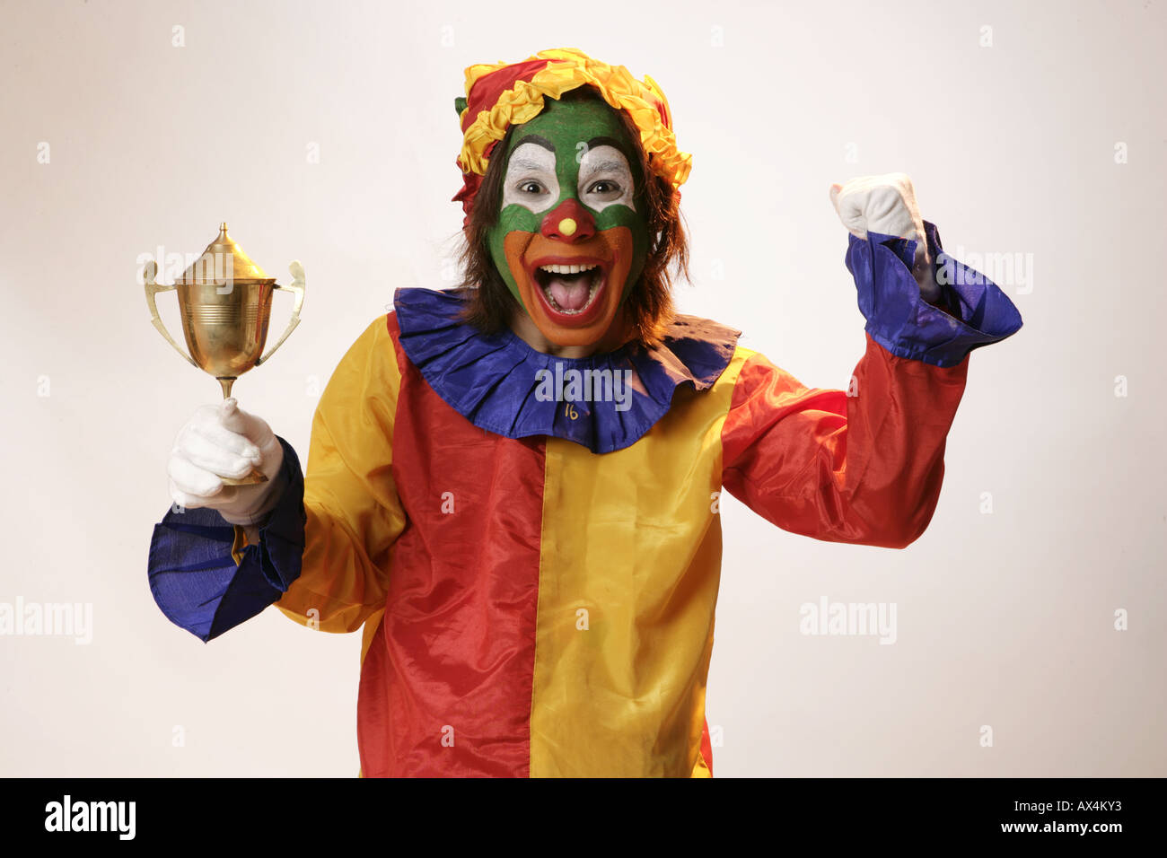 Ritratto di un joker tenendo un trofeo e rasserenanti Foto Stock