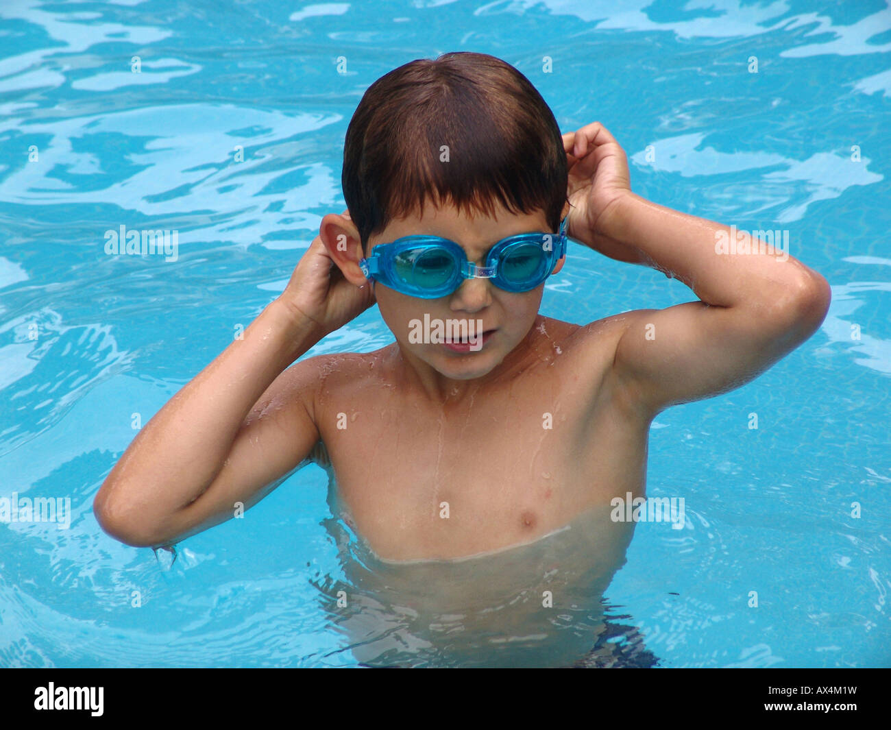Un giovane ragazzo con gogles nuoto nella piscina, Spagna Foto Stock