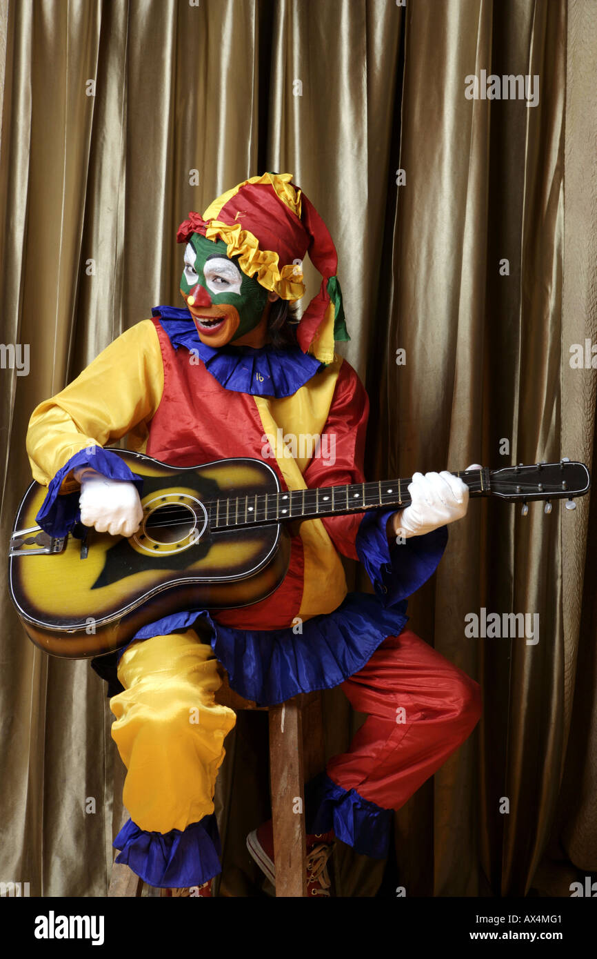 Joker a suonare la chitarra e sorridente Foto Stock