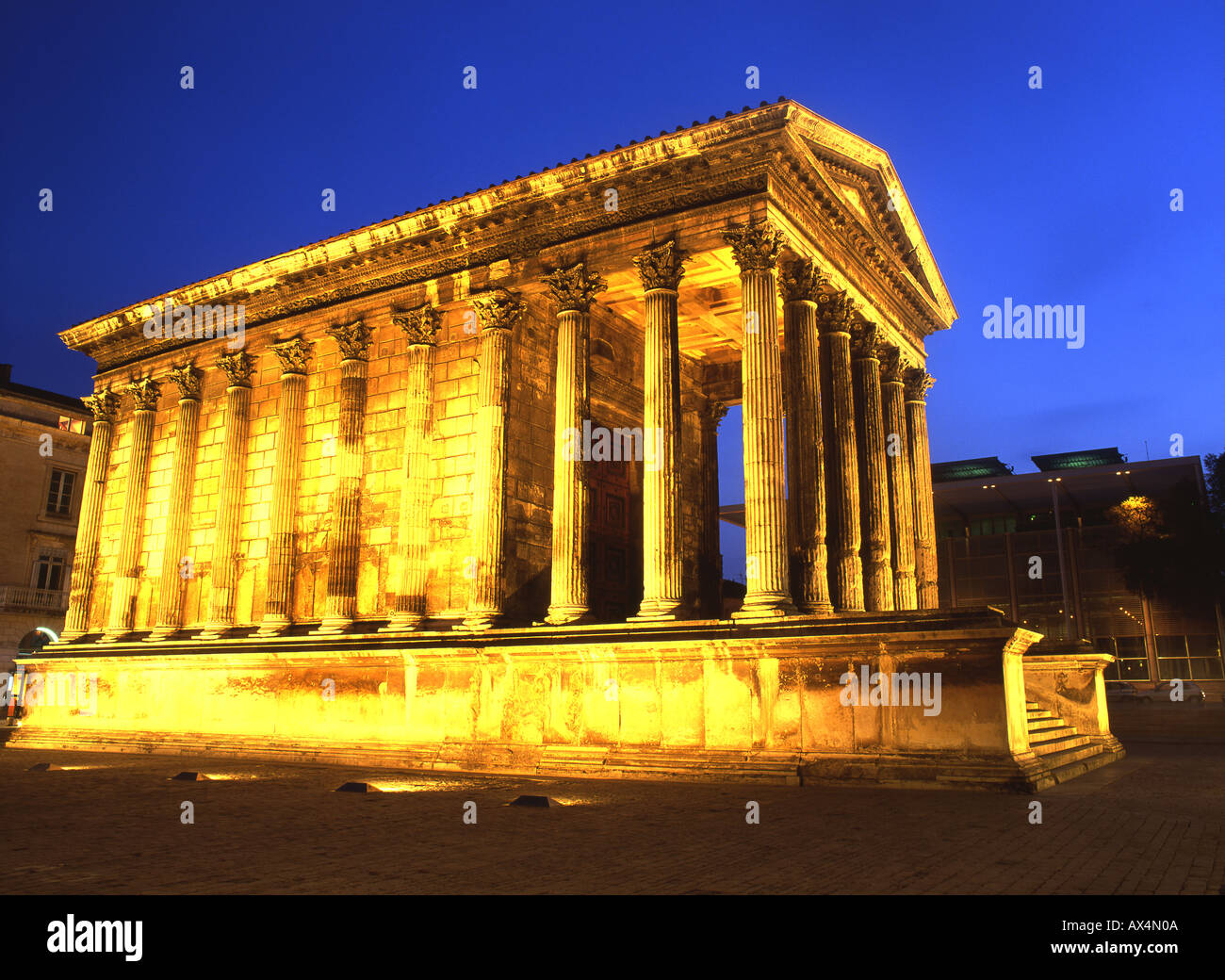 La Maison Carrée II secolo d.c. tempio romano di notte Carrée d'Art Museum di Norman Foster Nimes Languedoc Rousillon & Francia Foto Stock