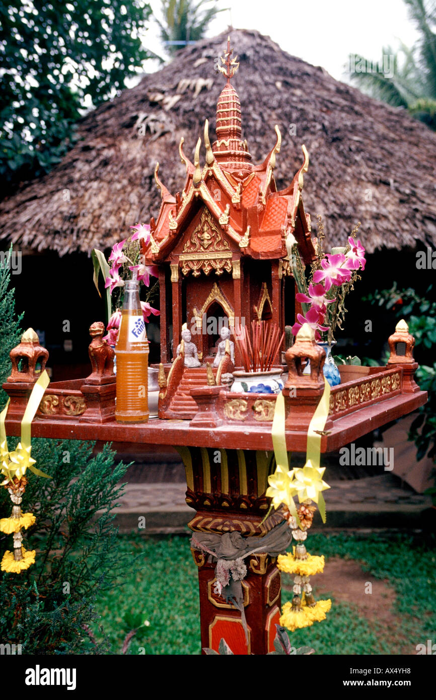 Un santuario buddista in Thailandia con una bottiglia aperta di Fanta a sinistra come un'offerta. Foto Stock