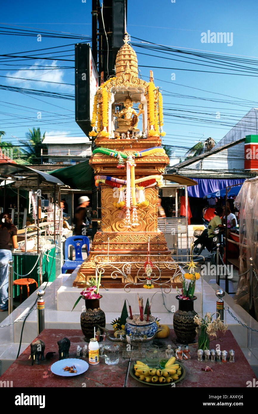 Un santuario buddista in Thailandia con una varietà di offerte. Foto Stock