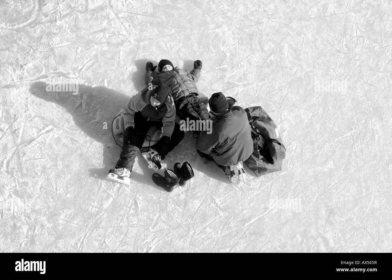 Un genitore contribuisce a legare i loro bambini pattini su Il Rideau Canal, i mondi più grande pista di pattinaggio ad Ottawa in Canada Foto Stock