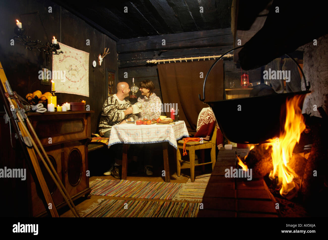 Giovane seduti a tavola in rifugio alpino Foto Stock