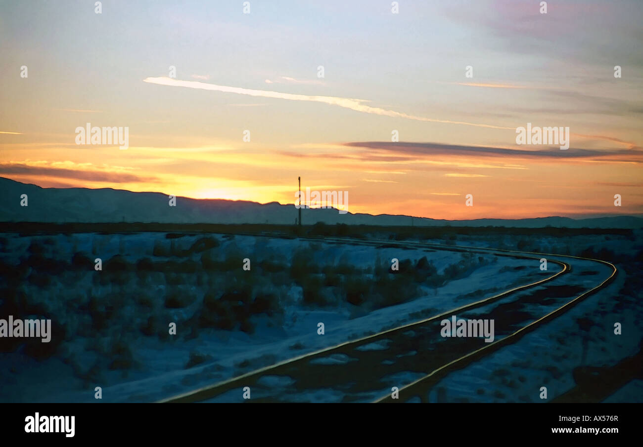 Uno splendido tramonto invernale a Salt Lake City, Utah, Stati Uniti d'America con una serie di antichi binari andando fuori verso il tramonto orizzonte. Foto Stock