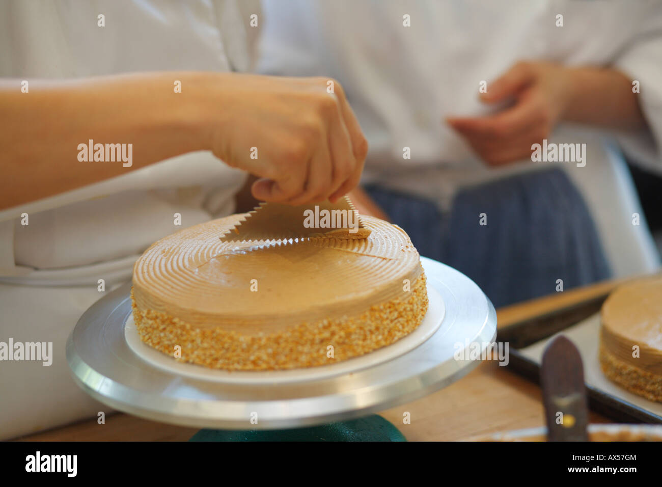 Pastry chef diffusione ciliegina su Caffè crema torta Foto Stock