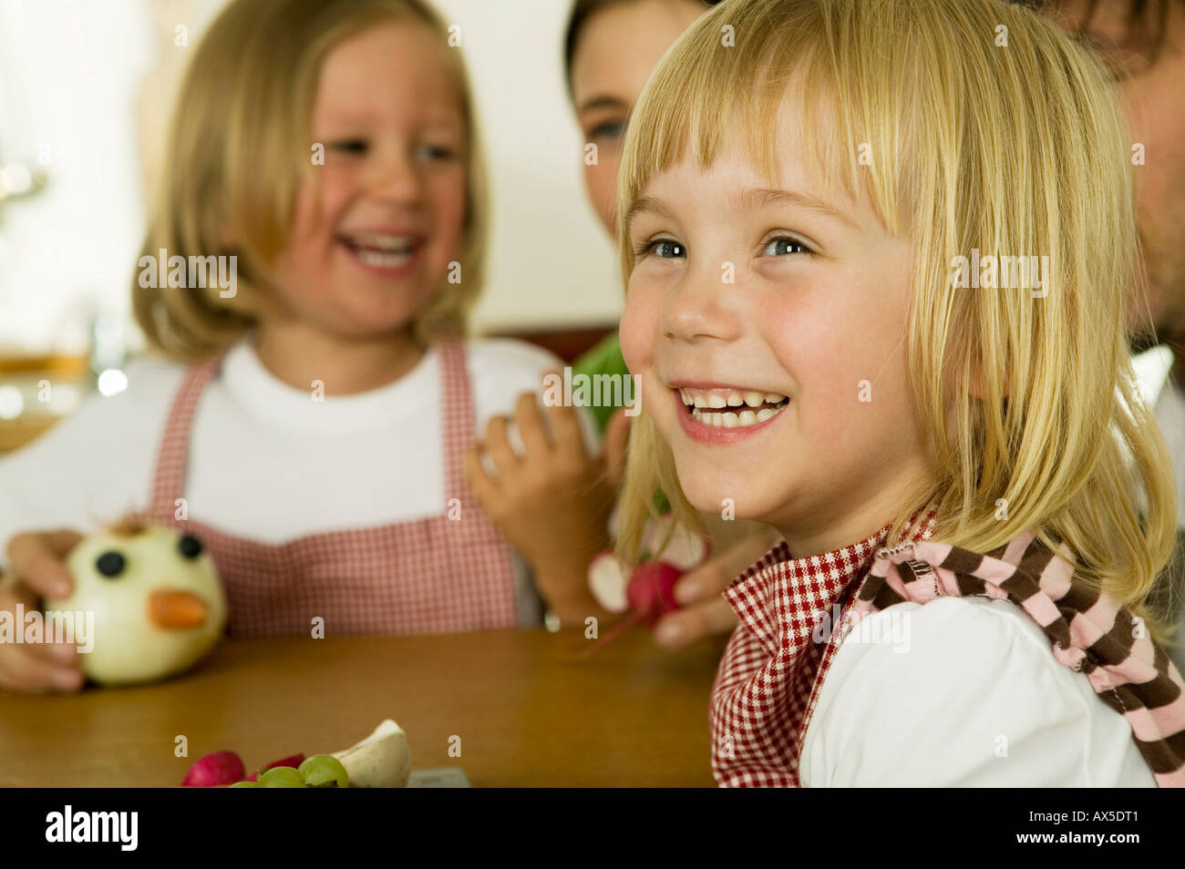 I genitori con bambini (2-4) giocando in cucina, sorridente Foto Stock