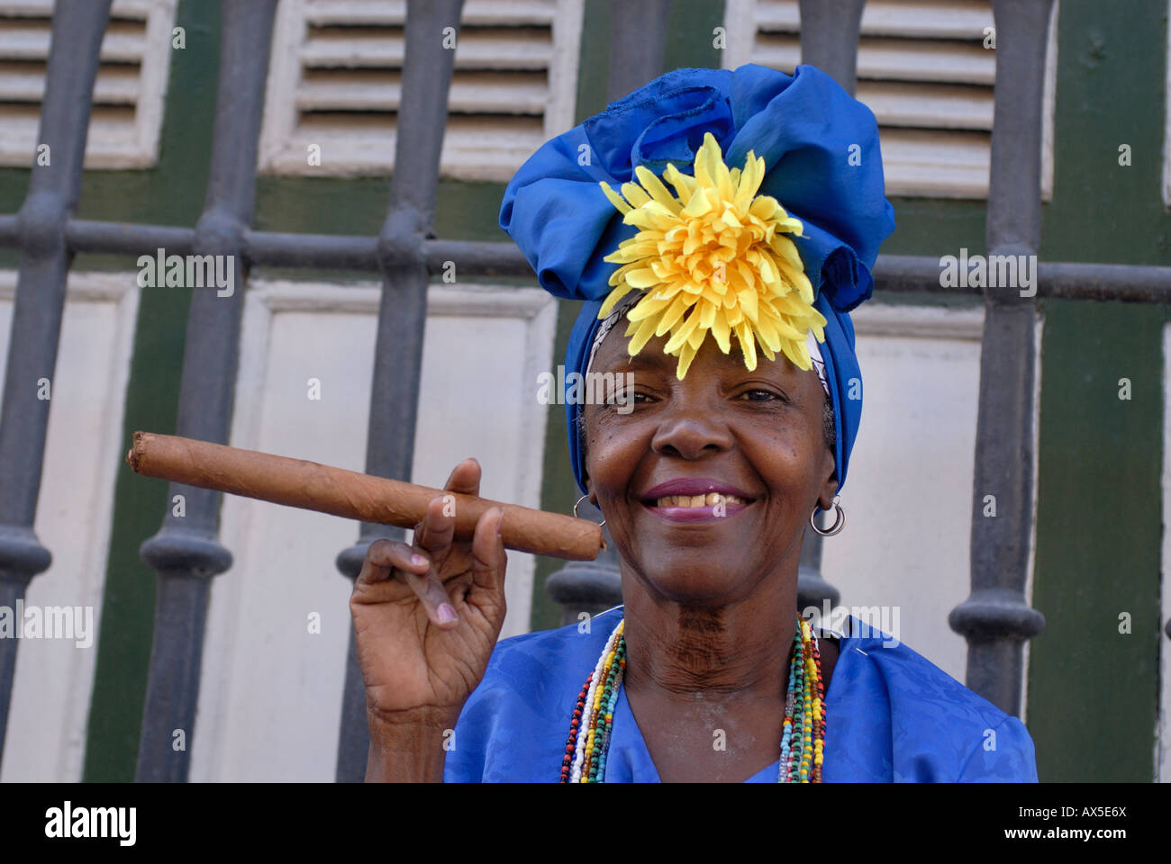 Donna che indossa abiti tradizionali tenendo un sigaro Avana, Cuba Foto Stock