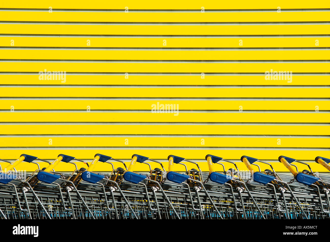 Impilate i carrelli della spesa di fronte a uno sfondo giallo, Eckental, Media Franconia, Baviera, Germania, Europa Foto Stock