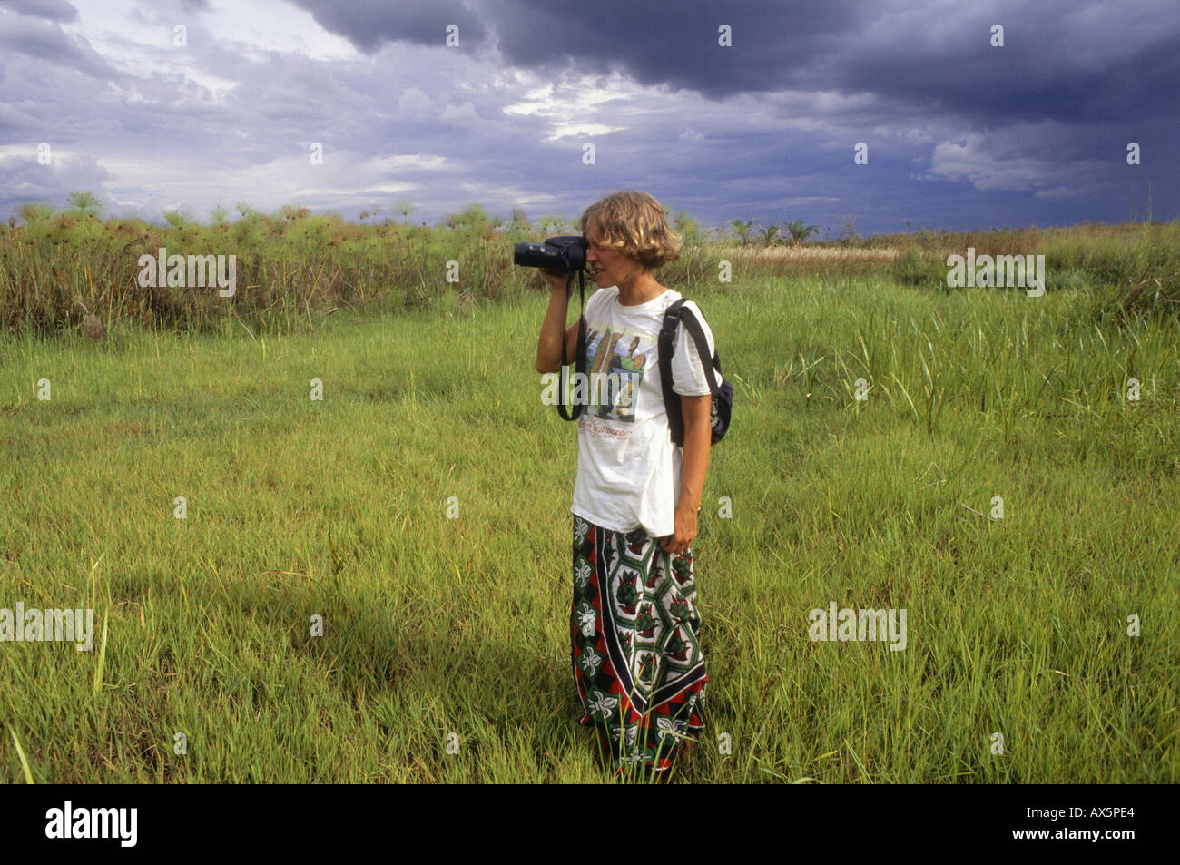 Zambia, Africa. Donna turistico con Olympus fotocamera per scattare una foto in papiro reed wetland. Foto Stock