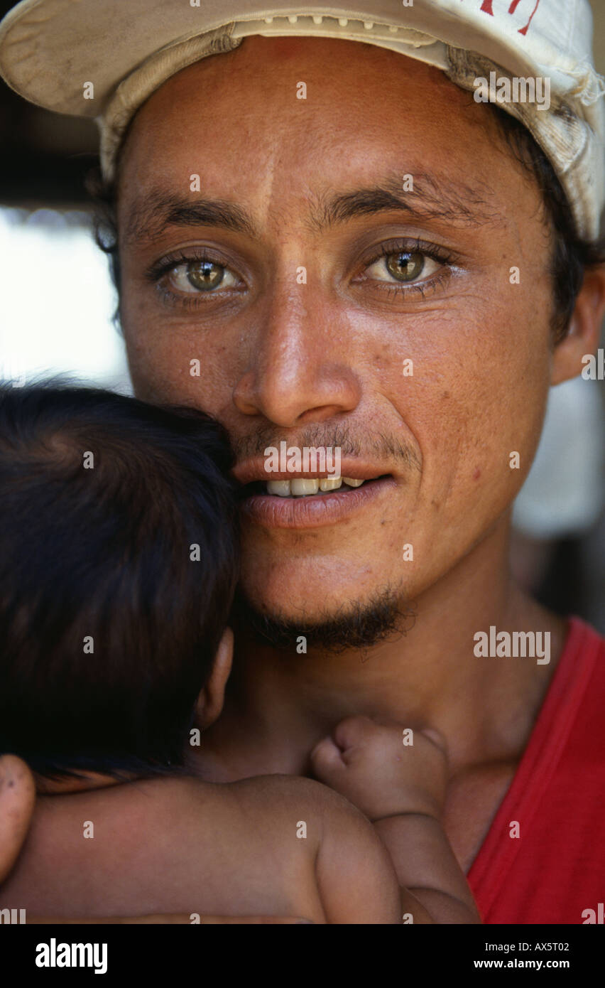 Para Stato, Brasile. Giovani caboclo padre con gli occhi verdi e una barba straggly tenendo il suo bambino. Foto Stock