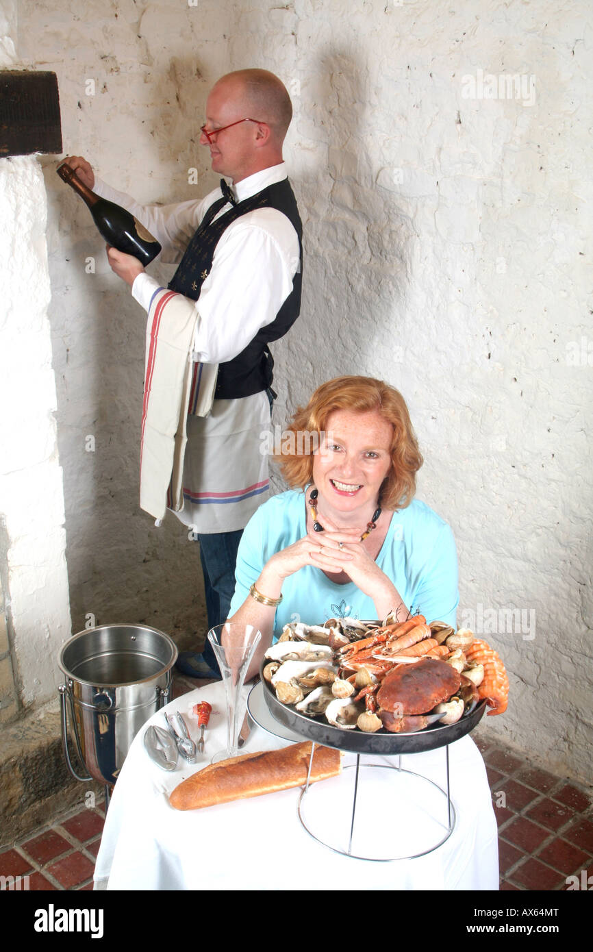 Signora giovane essendo atteso in un ristorante di pesce Foto Stock