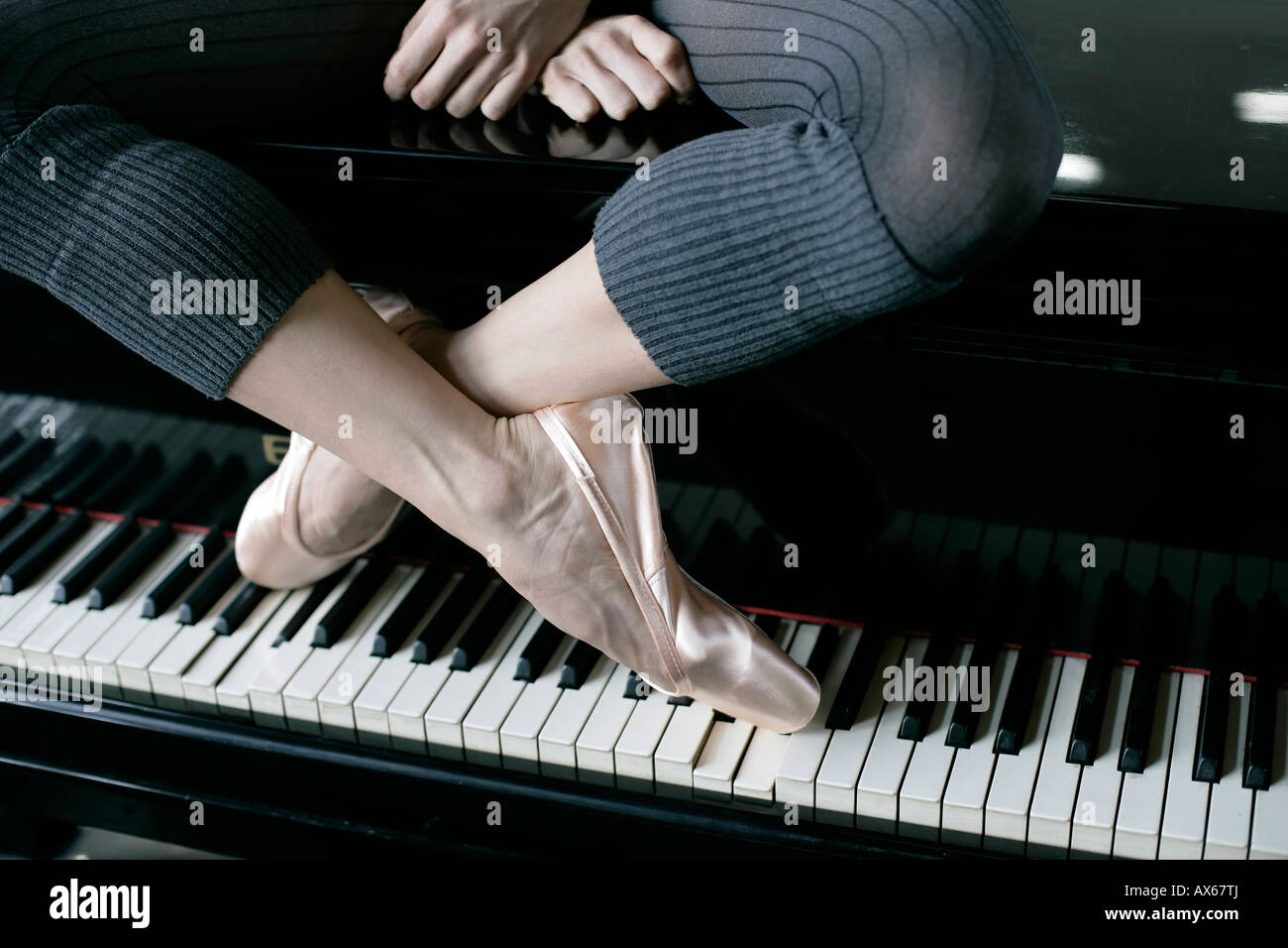 Una femmina la ballerina seduta su un pianoforte Foto Stock