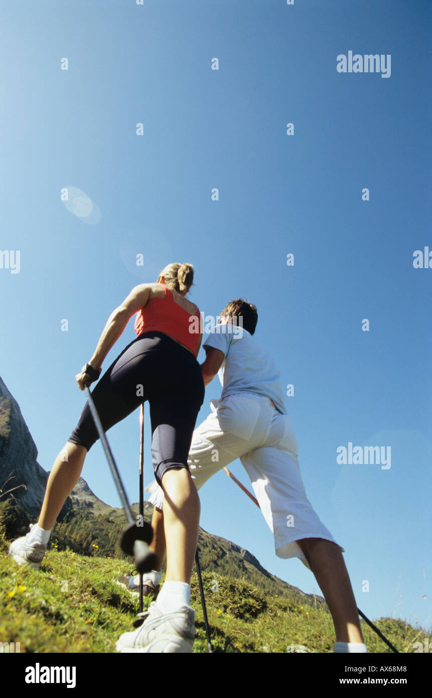 Paio di praticare il nordic walking in montagna, vista posteriore Foto Stock