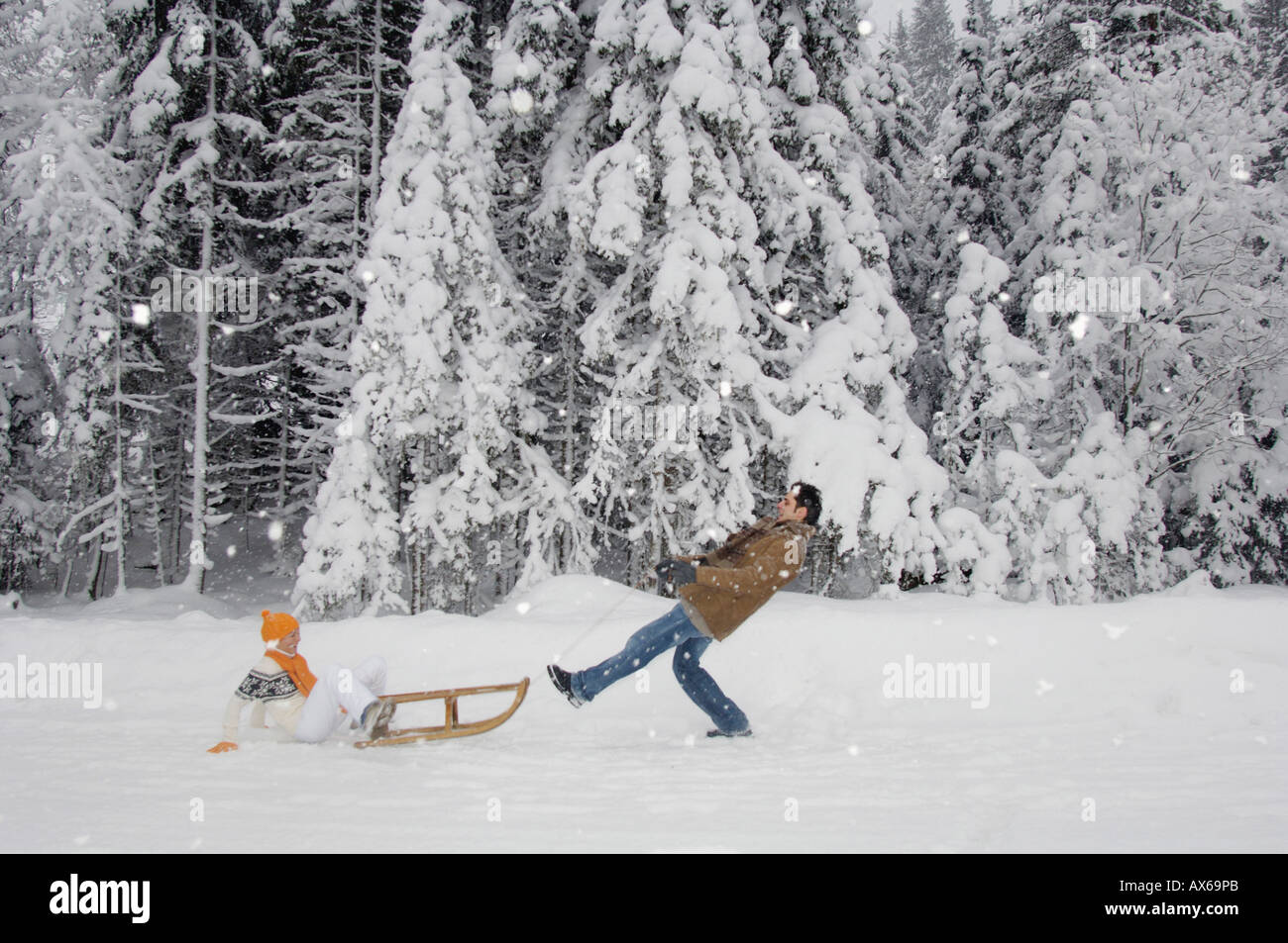 Coppia con lo slittino il divertimento nella neve Foto Stock