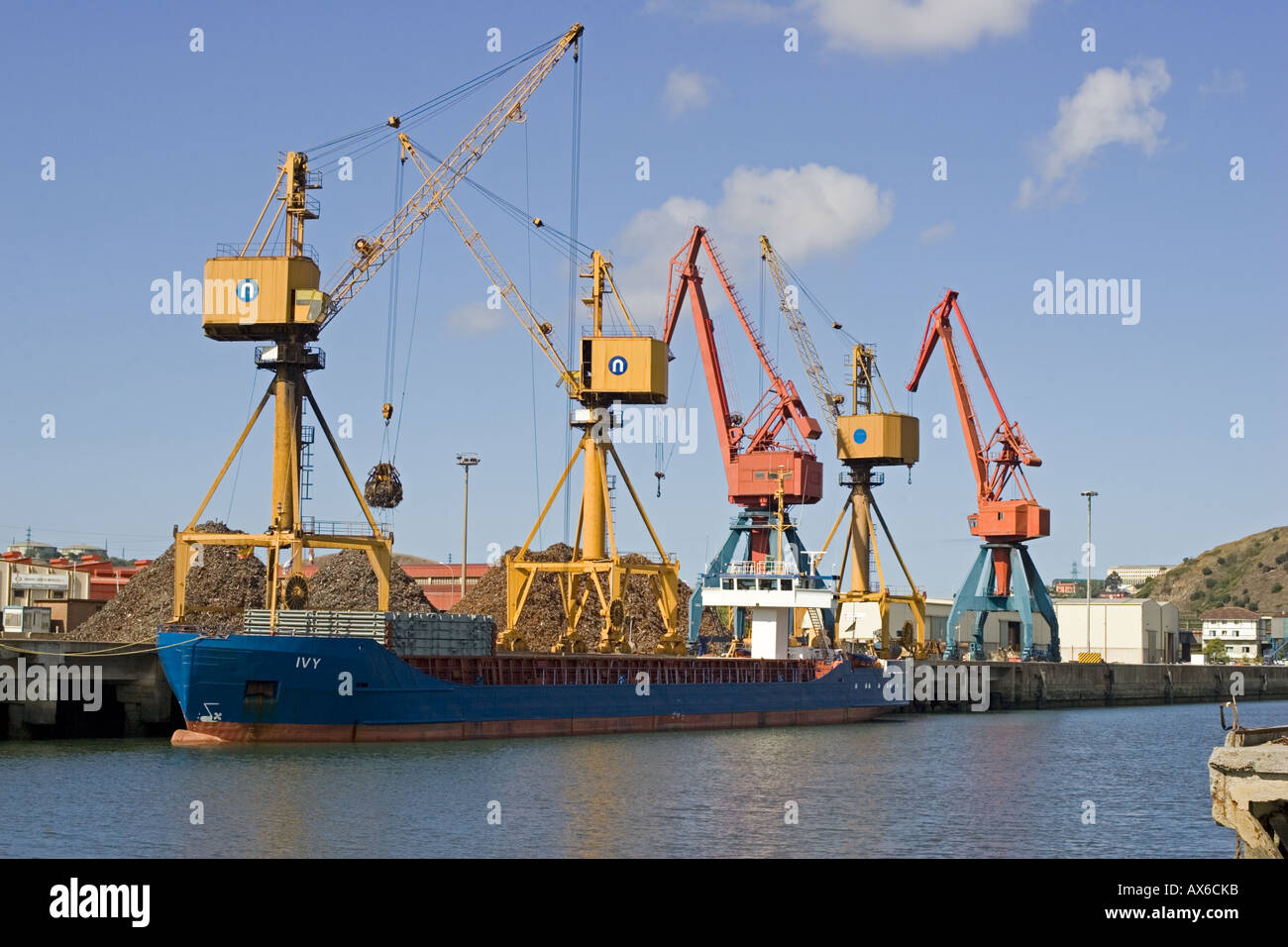 Gru sulla banchina di scarico di rottami di metallo da navi cargo nei camion per la rielaborazione di Bilbao docks Spagna Foto Stock