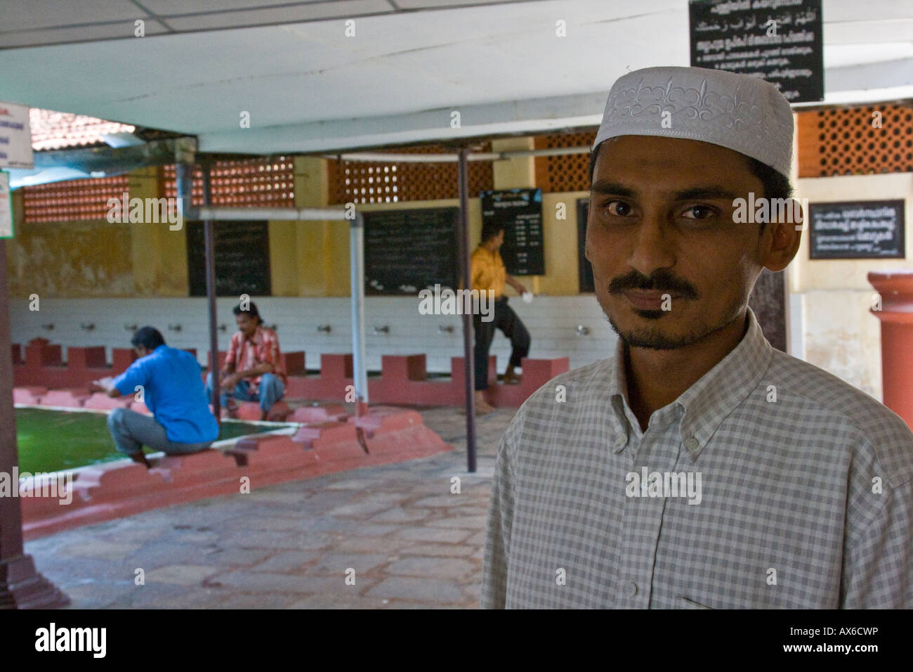 Uomo musulmano di fronte abluzione piscina in una moschea di Mattancherry Cochin India Foto Stock