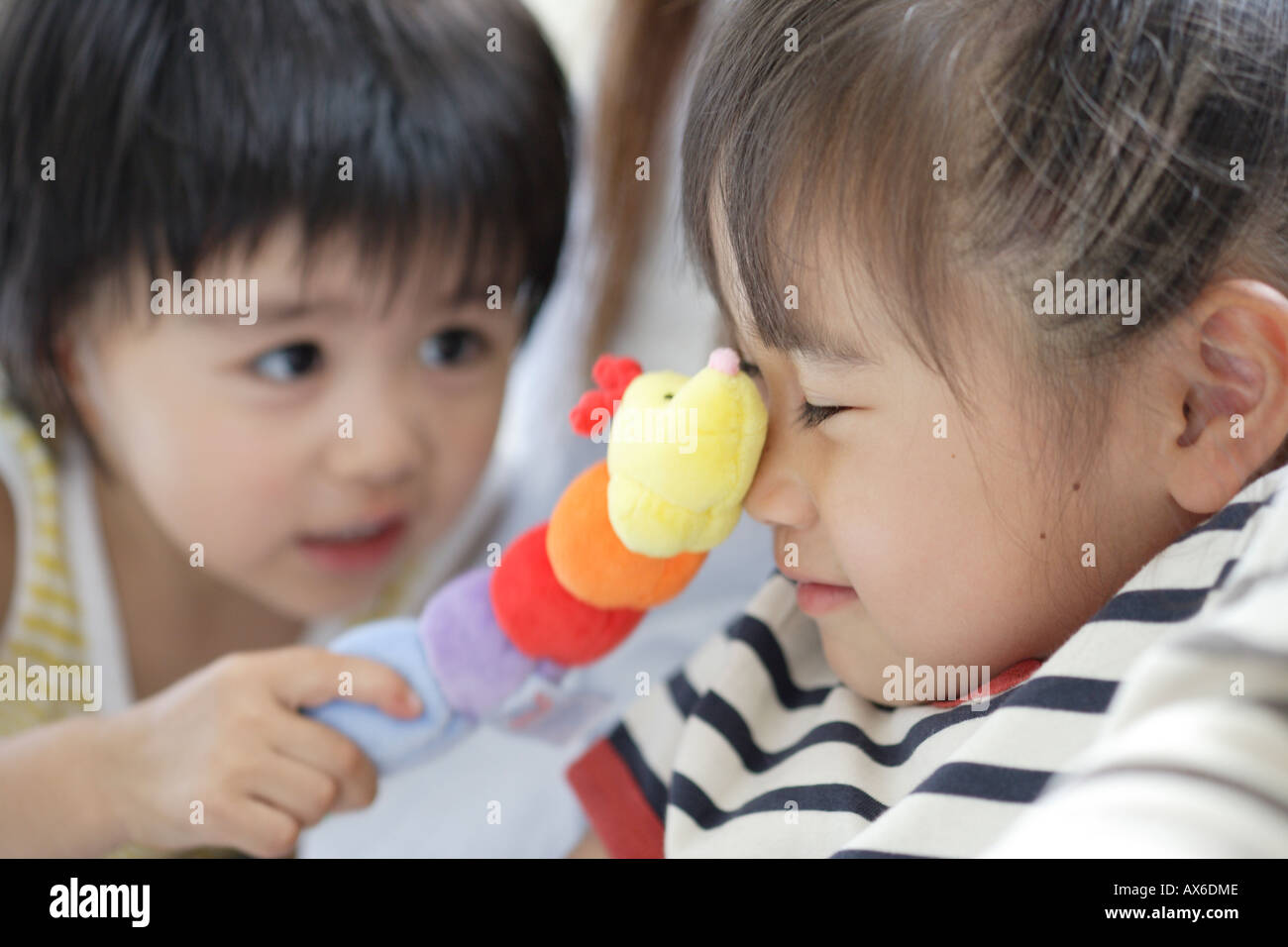 Sorella e fratello giocando con una bambola morbida Foto Stock