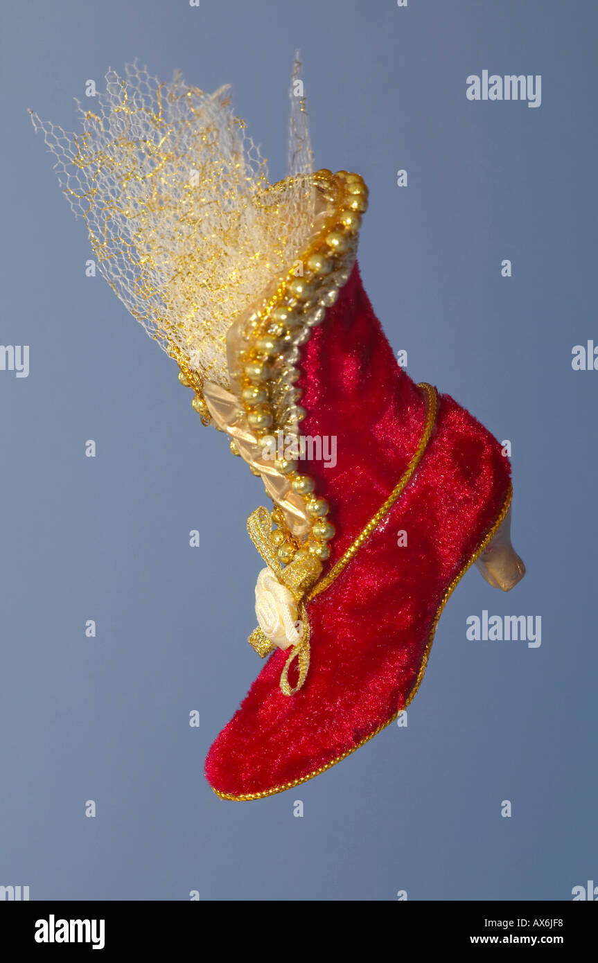 Decorazione per albero di Natale in forma di velluto rosso boot sulla pianura sfondo blu Foto Stock
