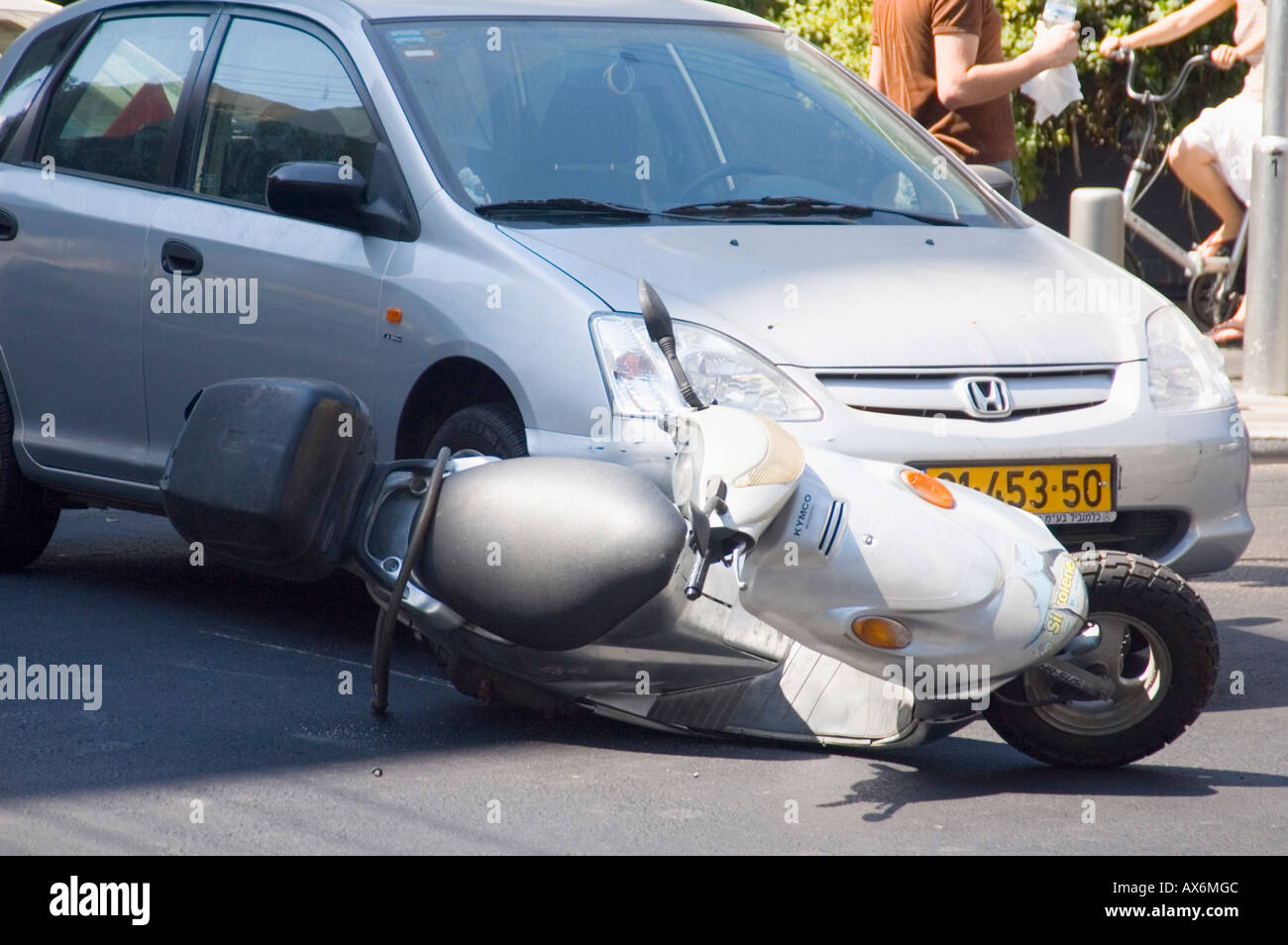 Un motore collisione tra un auto e una moto in una città incrocio Foto Stock