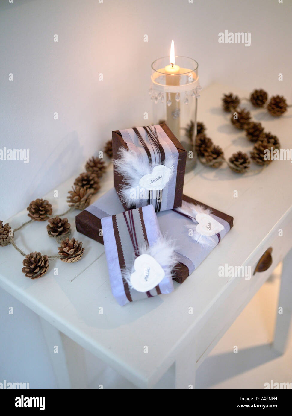 Regali di natale con pigne e candela accesa sul tavolo Foto Stock