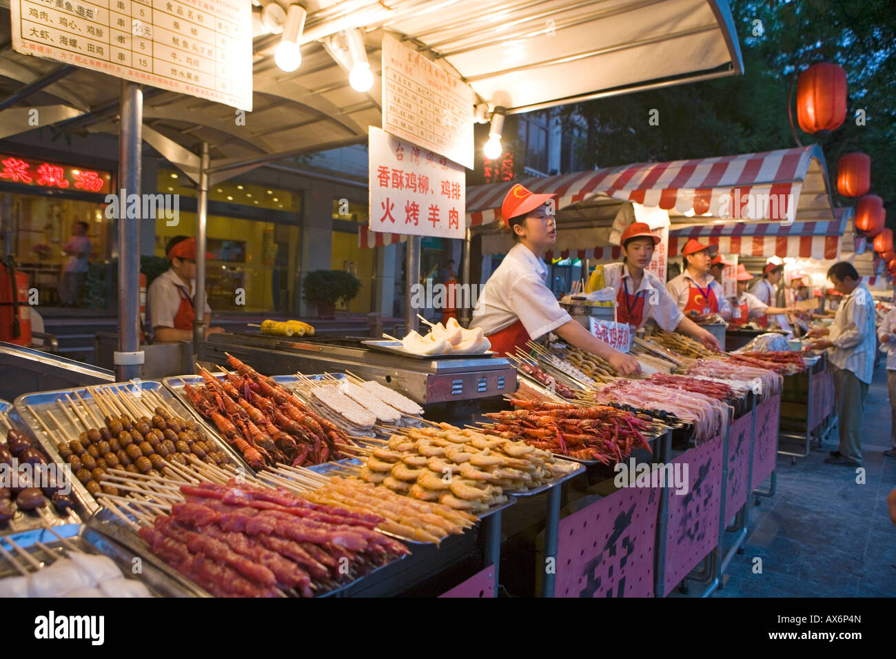 Venditori in piedi in bancarelle nel mercato alimentare di Pechino CINA Foto Stock