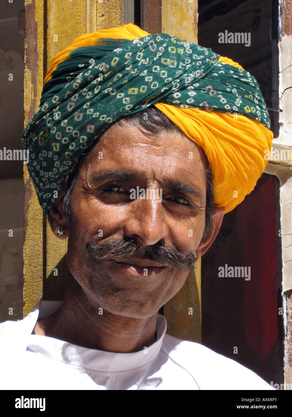 Uomo con arancione e verde turbante volto ritratto di baffi Foto Stock