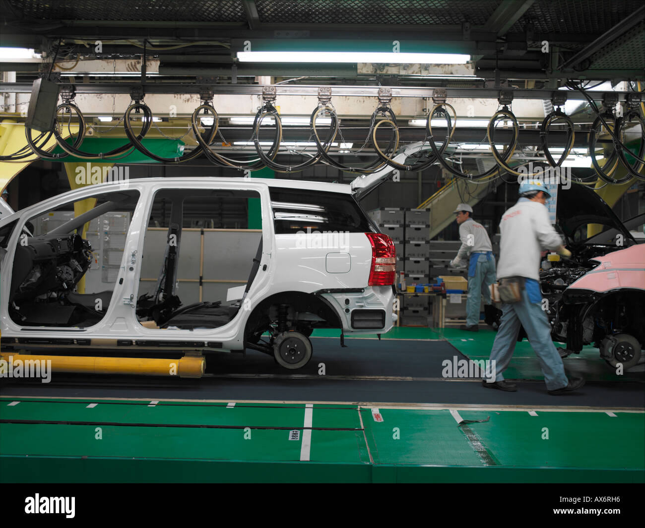 Lavoratori in fabbrica la produzione di ibridi Toyota Prius cars il lavoro sulla linea di montaggio a Toyota City Foto Stock