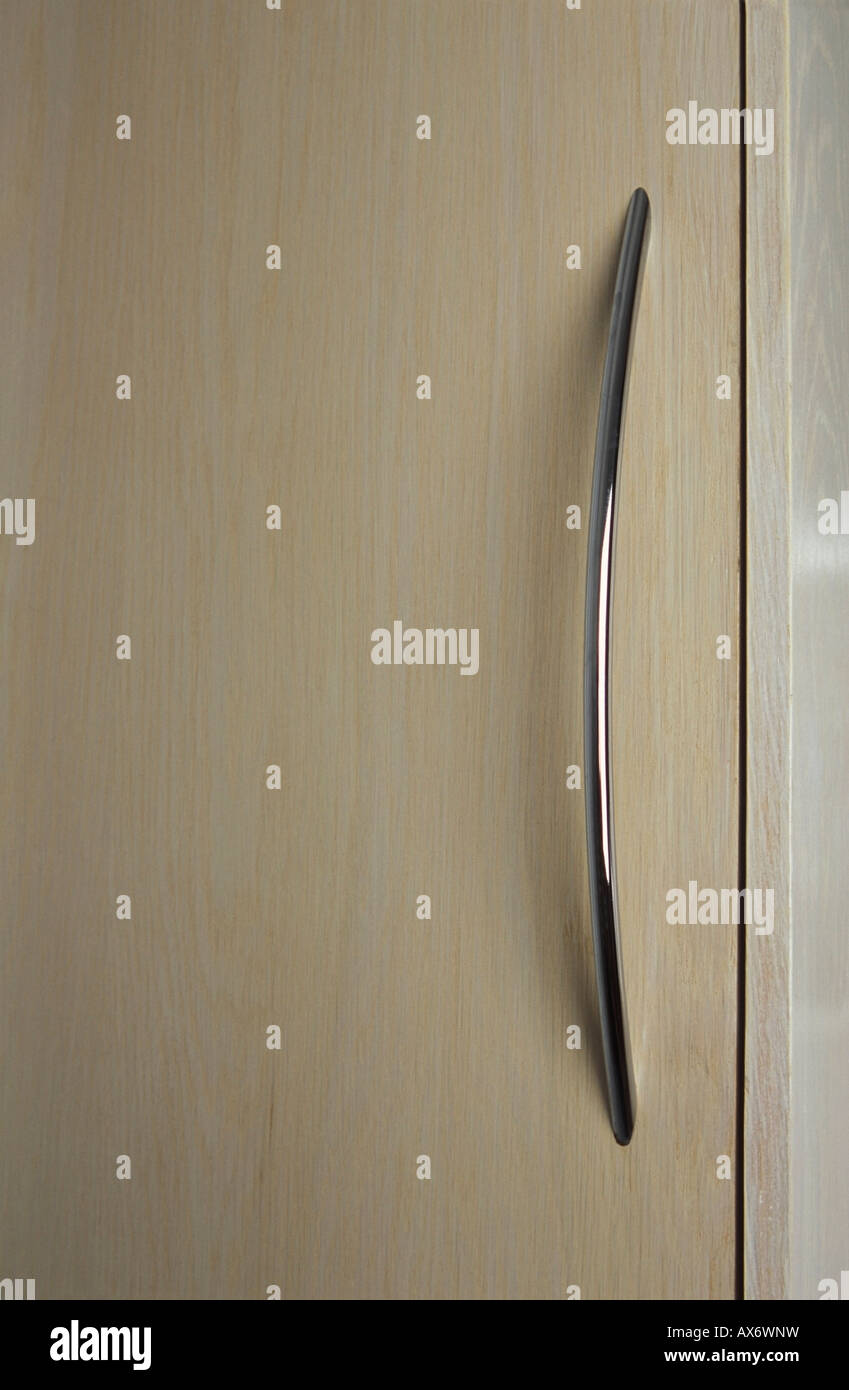 Singola maniglia cromata sulla credenza in legno porta Foto Stock