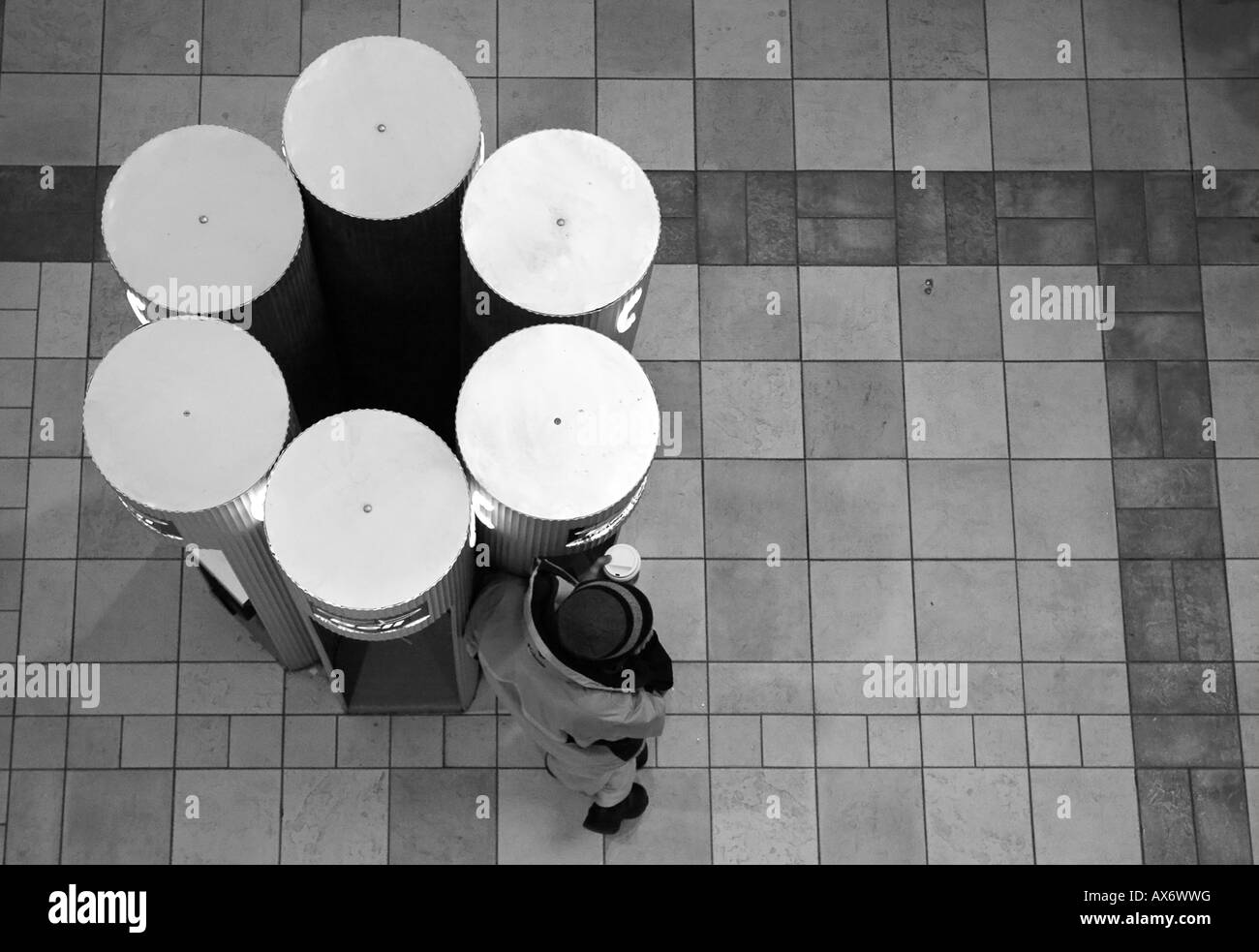 Un uomo fa una chiamata telefonica in uno dei molti telefoni pubblici Foto Stock