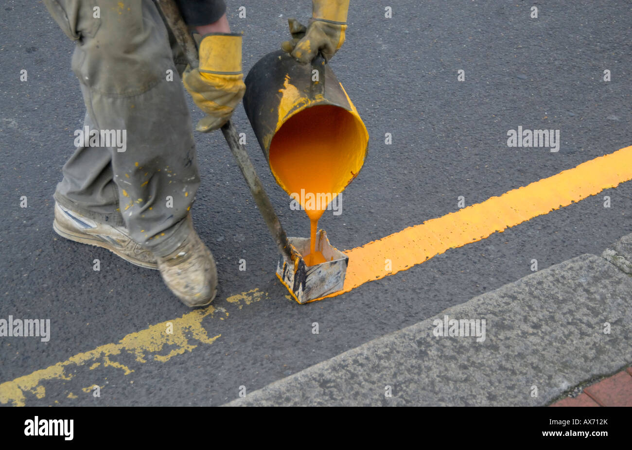 Pittura a mano singola linea gialla sulla strada con bollitore di acqua calda di vernice e utensile di marcatura, Cheam, Londra Sud, Surrey, Inghilterra Foto Stock