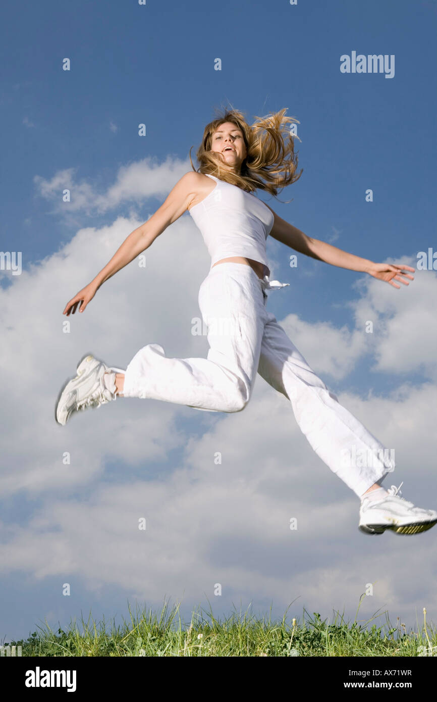Giovane donna jumping a metà in aria Foto Stock