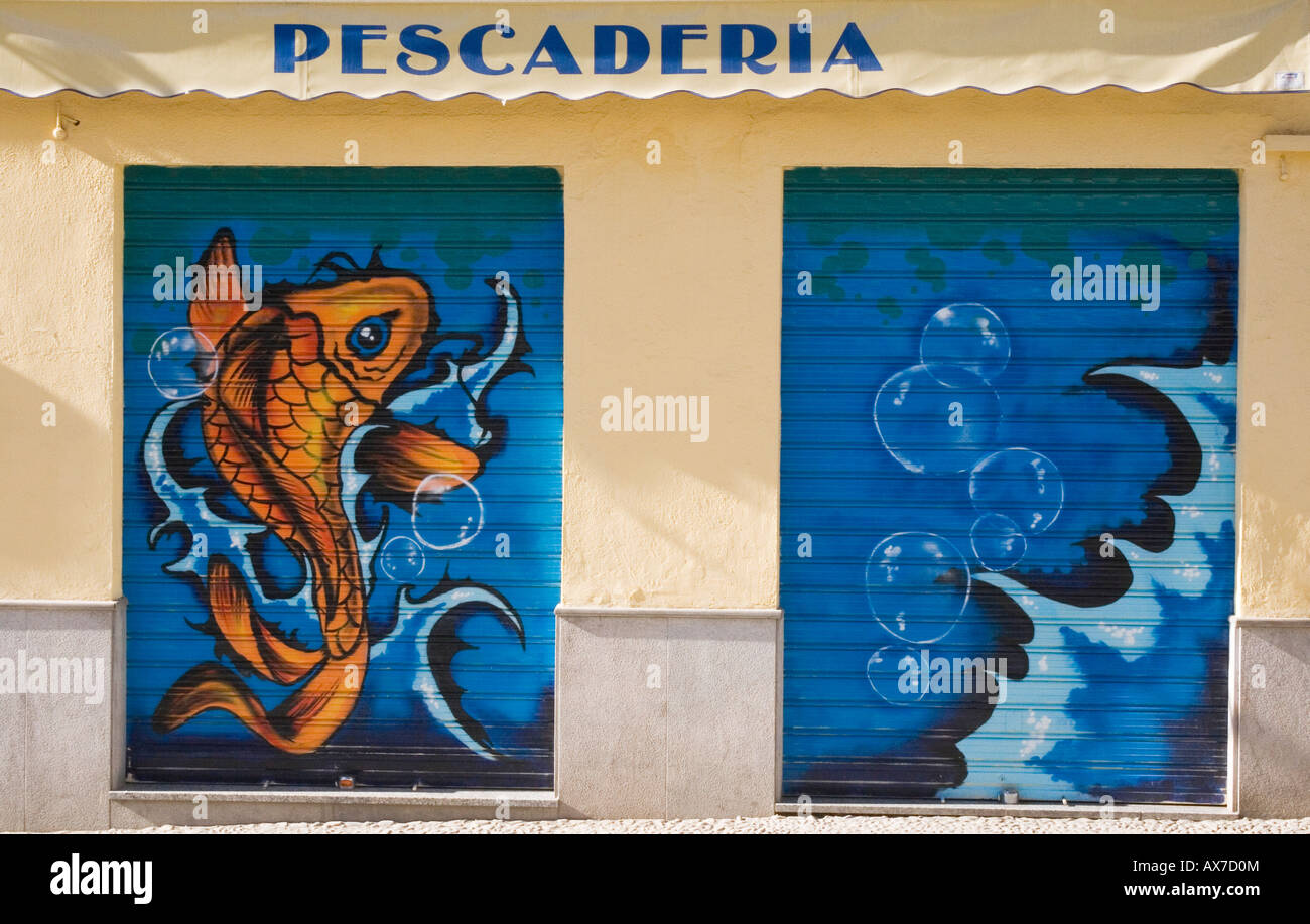 Granada Spagna graffiti dipinti su imposte sulla parte anteriore del negozio di pesce Foto Stock
