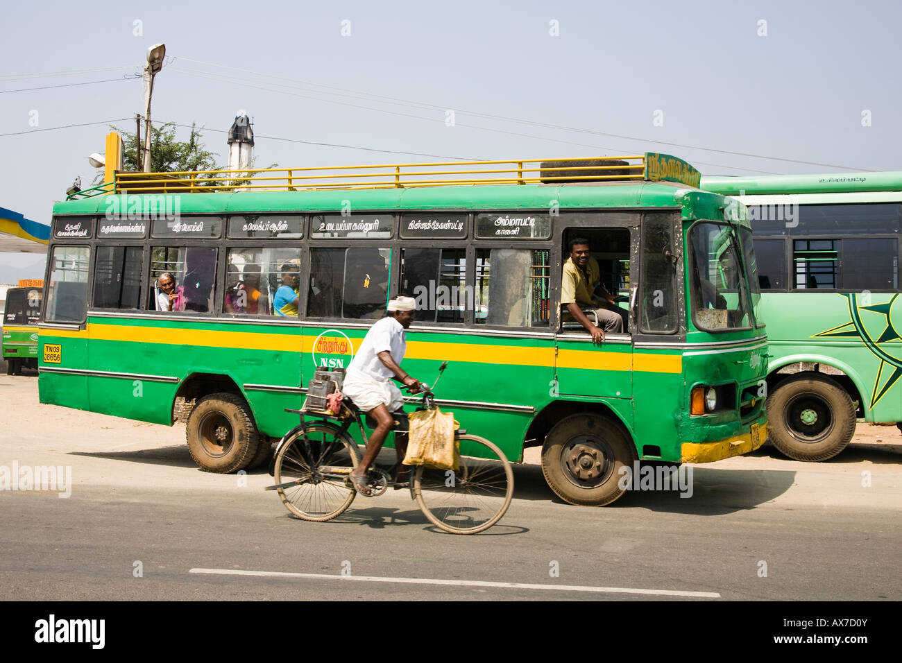 Un autobus pubblici che viaggiano lungo la strada e il ciclista, Tamil Nadu, India Foto Stock