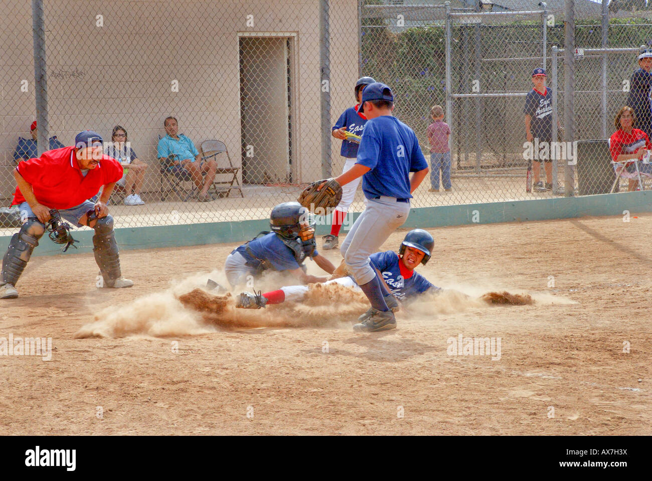 Little League Baseball player scorre nella piastra di casa durante il gioco non rilasciato Foto Stock