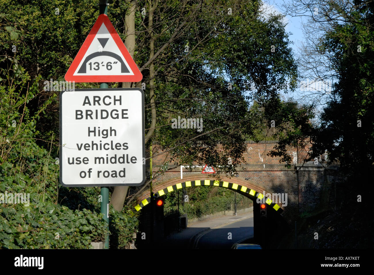 Bassa il ponte di arco cartello di avviso e di alta visibilità marcature sul ponte della ferrovia, Cheam, Londra Sud, Surrey, Inghilterra Foto Stock