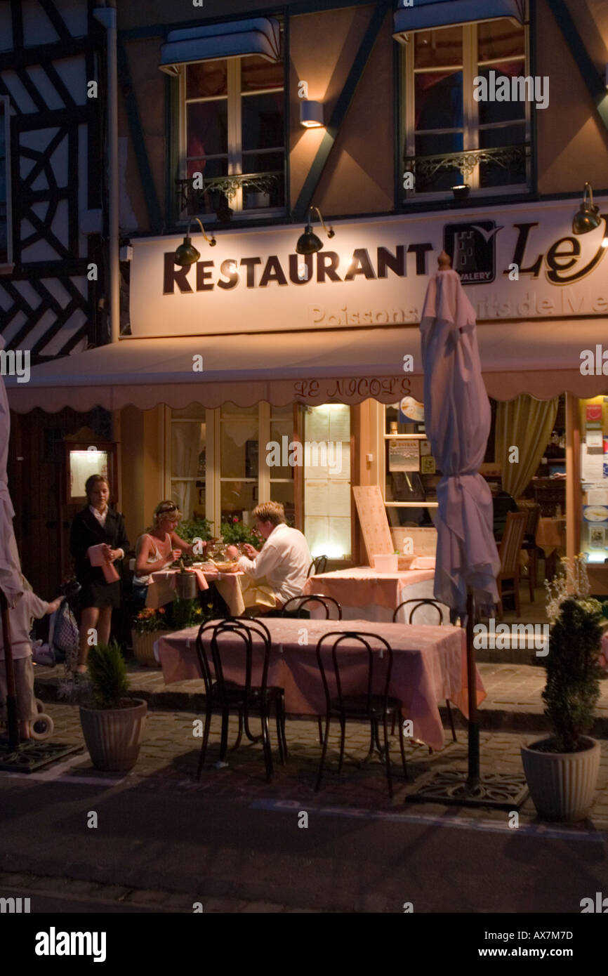 Famiglia gustando un pasto serale fuori del ristorante nel centro di St Valery sur Somme Foto Stock