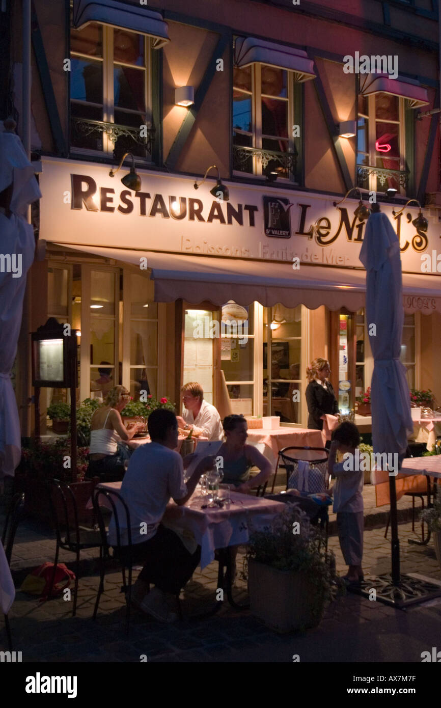 Famiglia gustando un pasto serale fuori del ristorante nel centro di St Valery sur Somme Foto Stock
