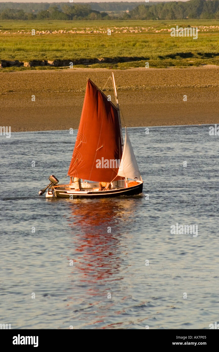 Barche a vela rientro al porto come sole comincia a impostare su somme estuario St Valery sur Somme Foto Stock