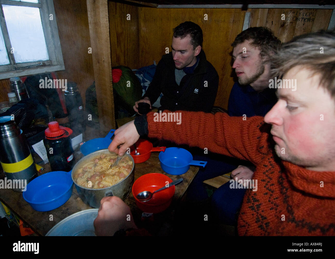 Gli istruttori hanno un rifugio caldo per una base mentre gli studenti vivono in un foro di neve settimana di sopravvivenza danese Forze Speciali cane Sirius Foto Stock