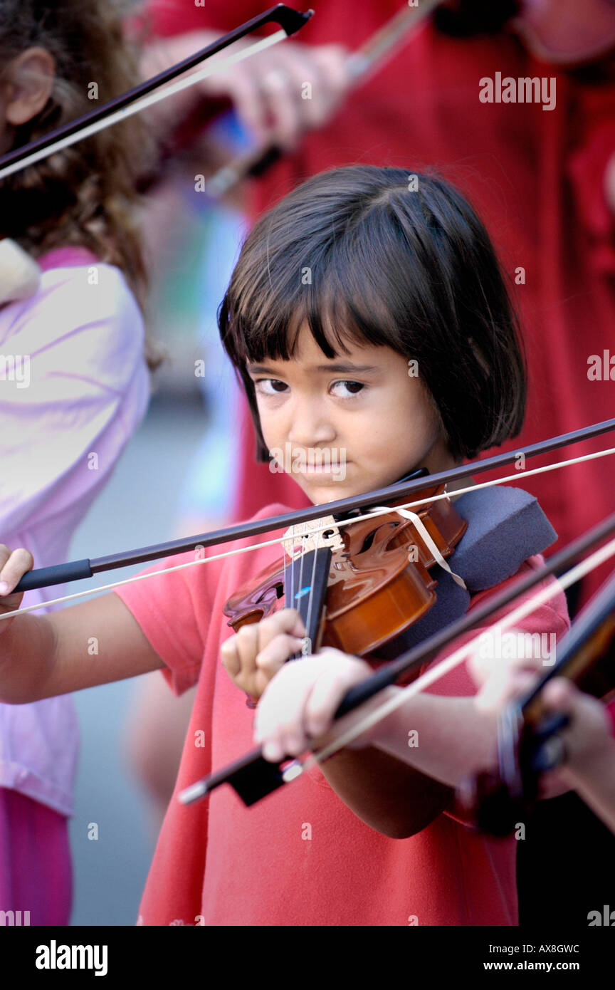 Le corde di un violino gruppo costituito da bambini giocano un punto esterno per il pubblico Foto Stock