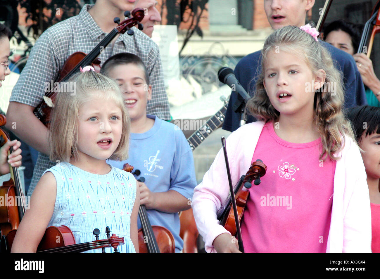 Le corde di un violino gruppo costituito da bambini giocano un punto esterno per il pubblico Foto Stock