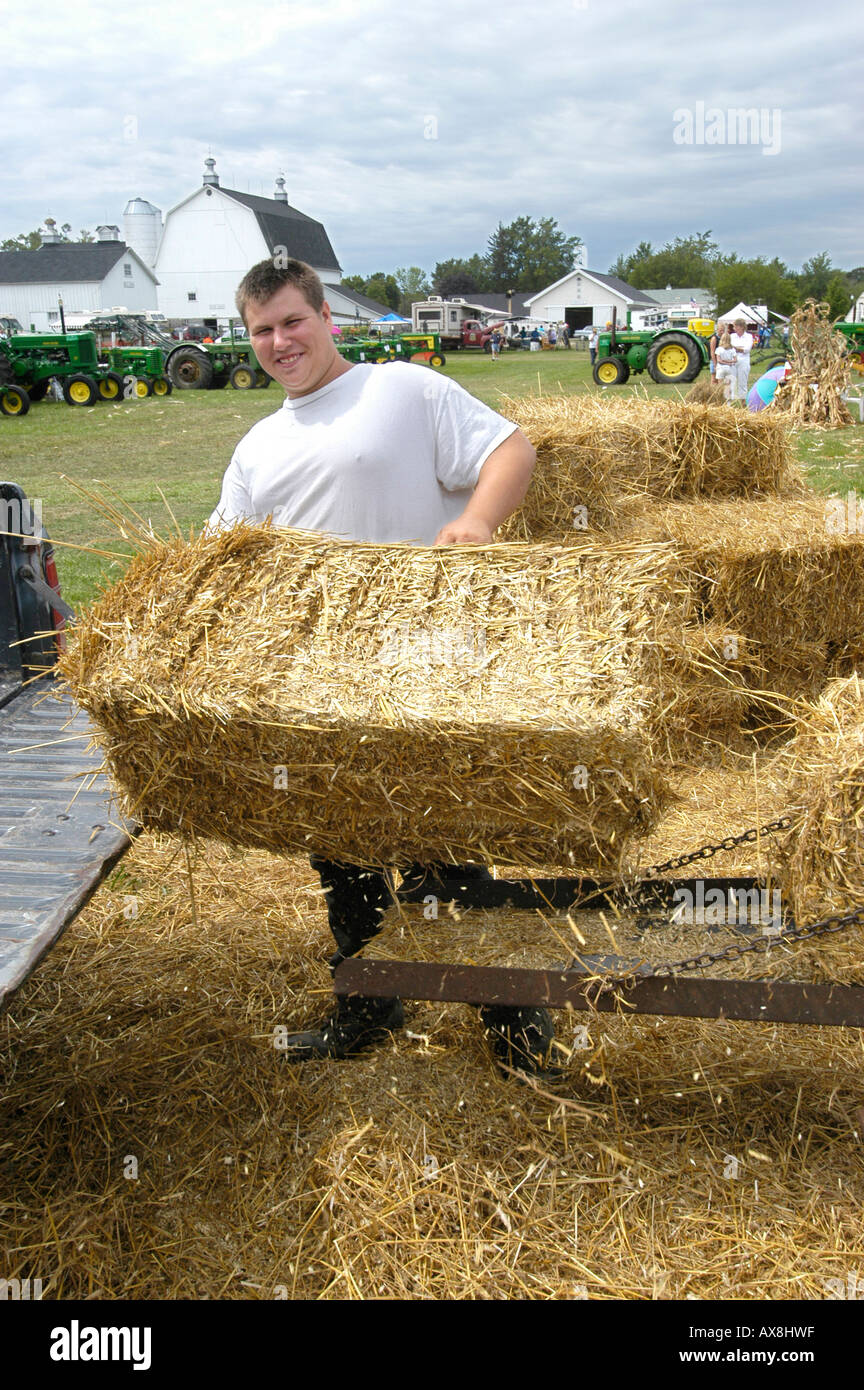 Imballano paglia in bails quadrato in un momento storico agricoltura giorno vivere evento cronologia Foto Stock
