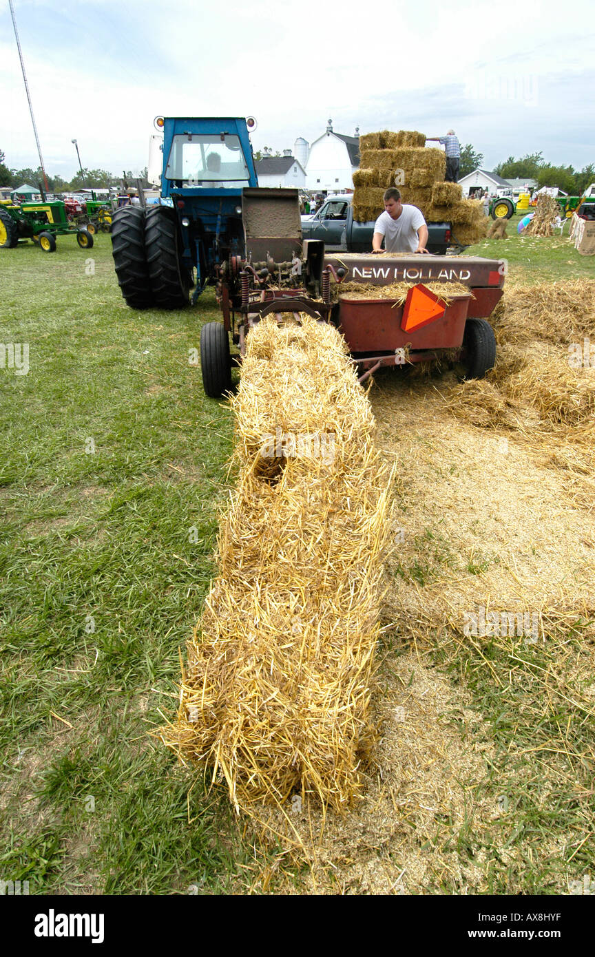 Imballano paglia in bails quadrato in un momento storico agricoltura giorno vivere evento cronologia Foto Stock