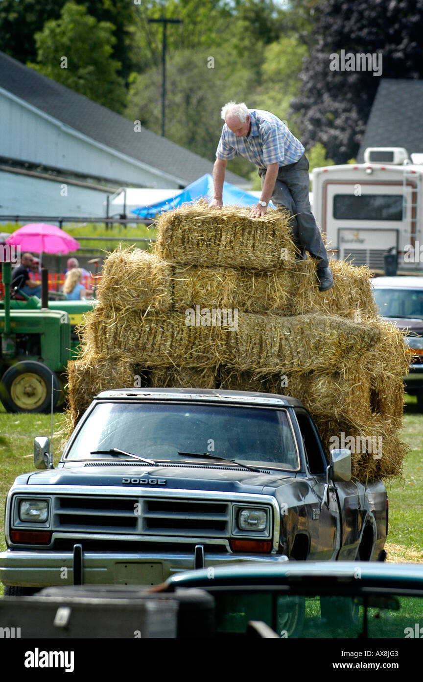 Imballano paglia in bails quadrato in un momento storico agricoltura giorno vivere evento cronologia Foto Stock