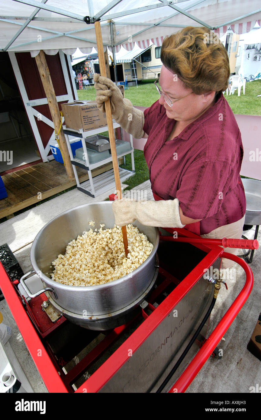 Piccola donna eseguire attività di vendita di bollitore popcorn Foto Stock