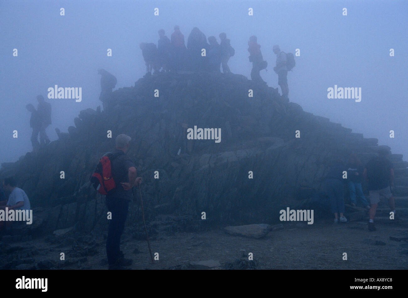 Gli alpinisti sulla cima di Mount Snowdon nella nebbia. Foto Stock